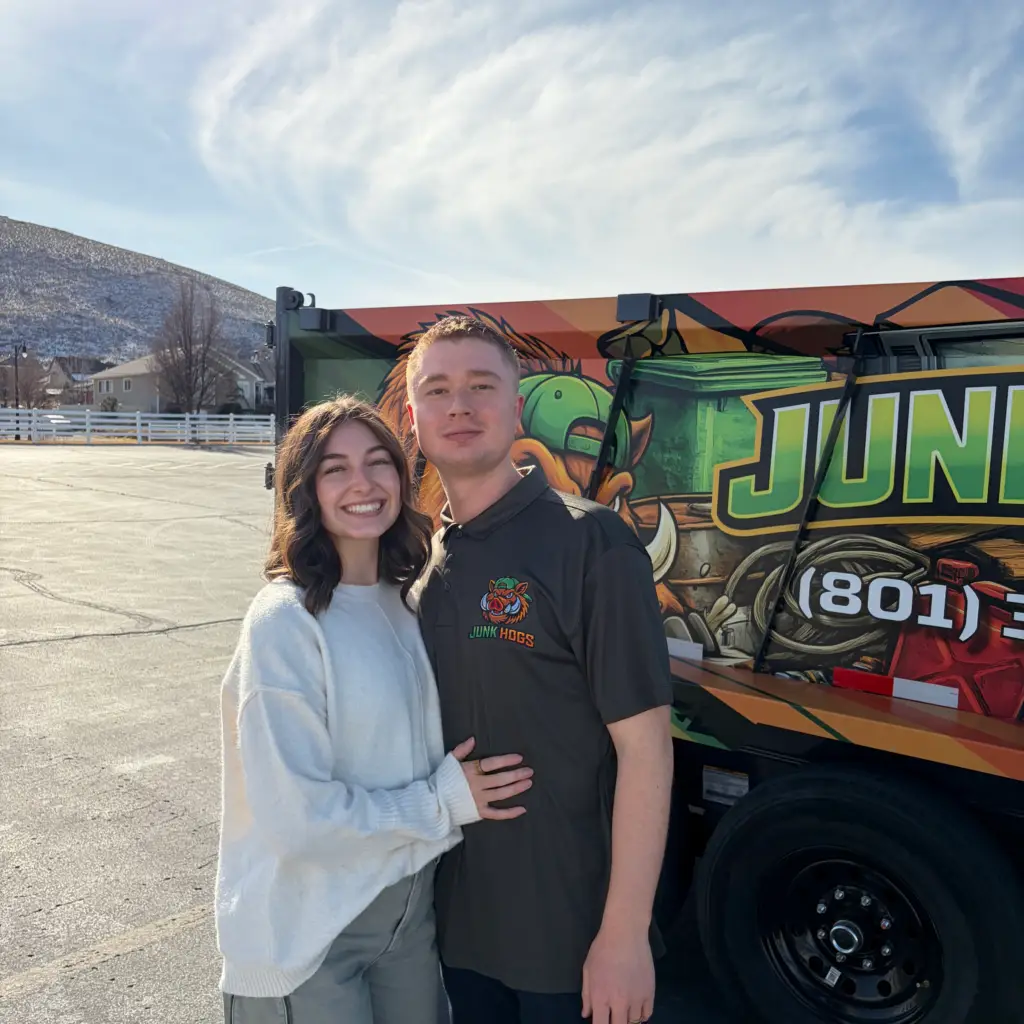 Junk Hogs team standing in front of the wrapped dump trailer
