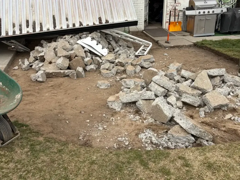 Broken concrete patio torn out and piled for haul away beside a Utah home