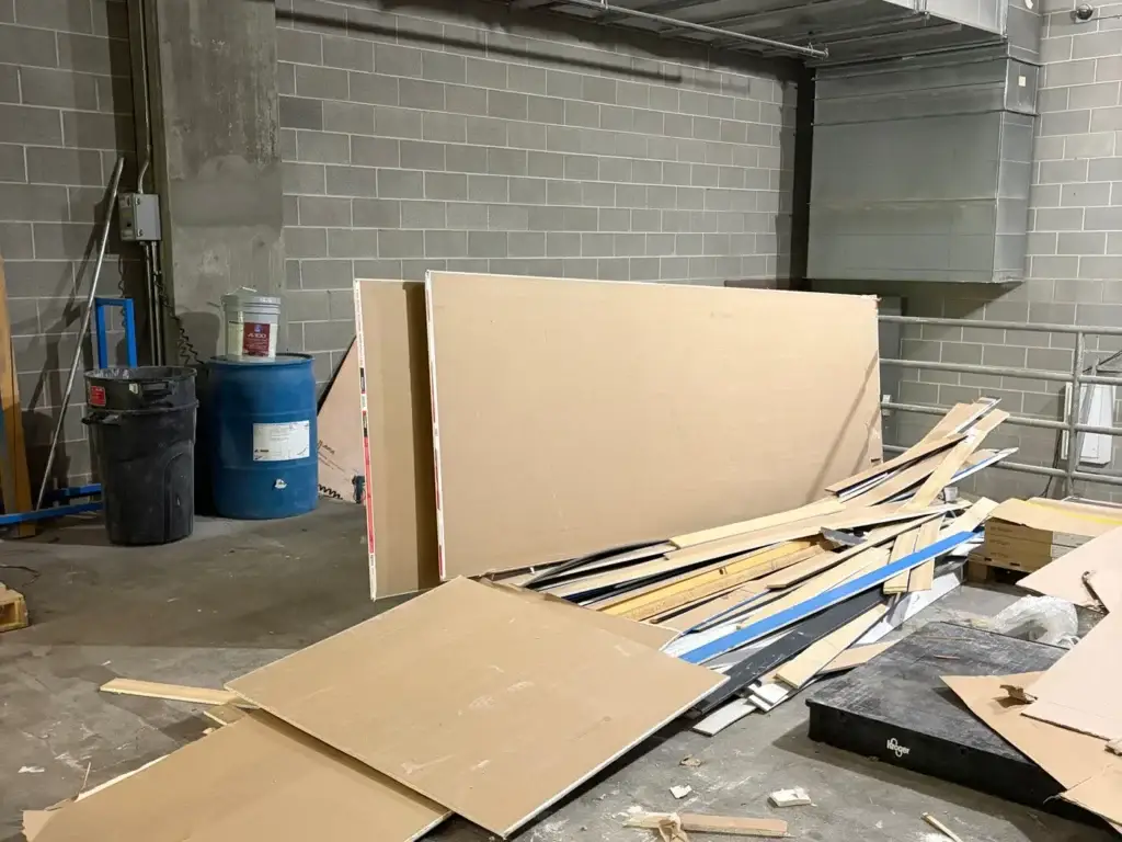 Commercial interior with drywall, trim and construction debris across the floor before clearing